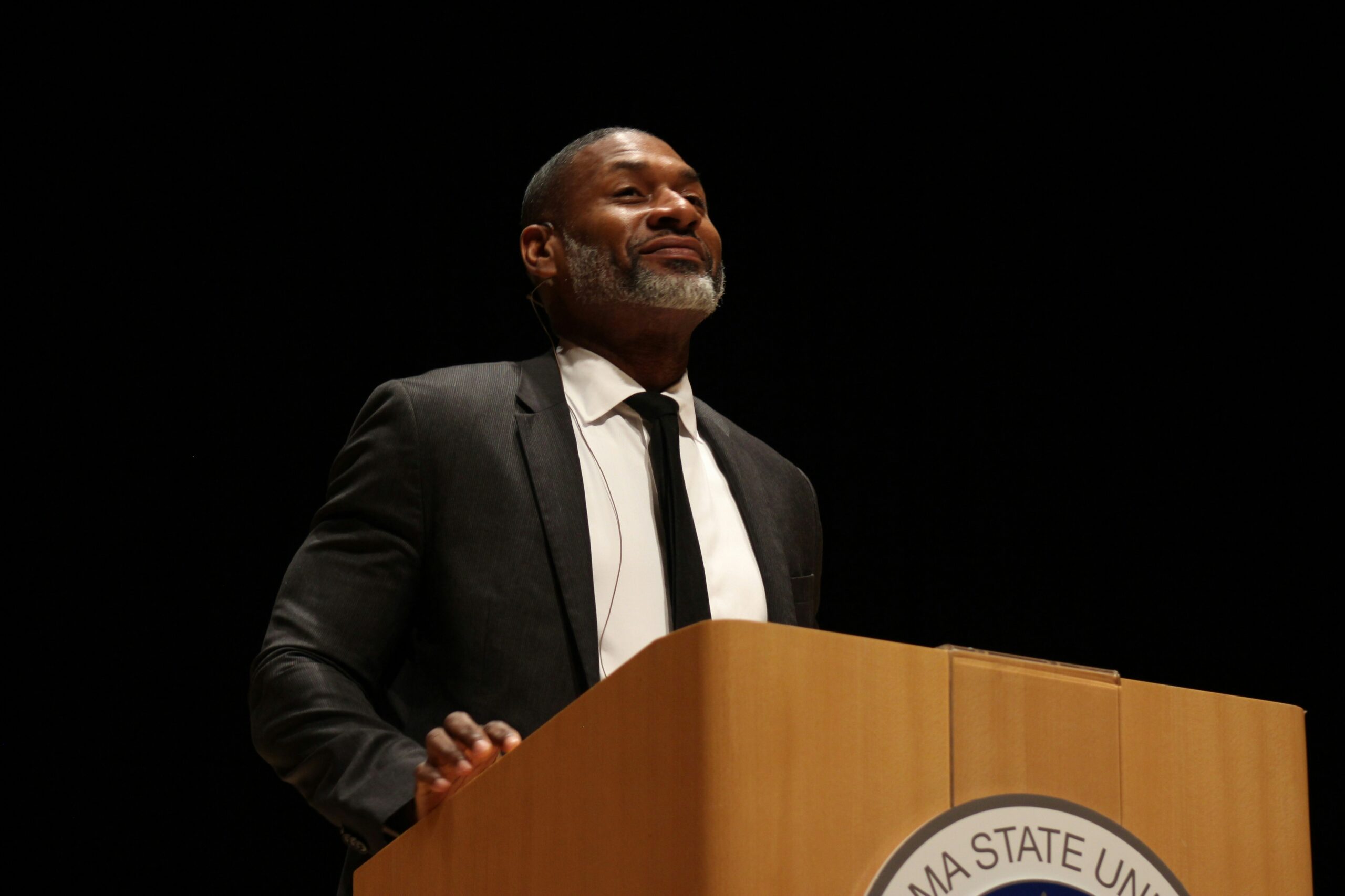 Homme politique prononçant un discours professionnel derrière un pupitre.